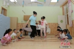 料图：老师带领孩子们在教室内游戏。中新社记者 张远 摄 - 中国新闻社河北分社