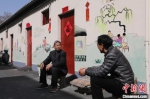 居民坐在改造后小区的彩绘墙下聊天。　霍金涛 　摄 - 中国新闻社河北分社