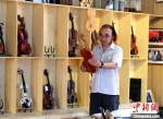 李世其在查看制作好的小提琴。　贾枭梦 摄 - 中国新闻社河北分社