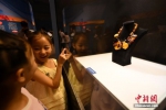 7月18日，小女孩被波罗的海蜜蜡饰品吸引。 - 中国新闻社河北分社
