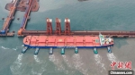装载约40万吨巴西铁矿石的“远谷海”轮在拖轮的协助下向曹妃甸港区矿石码头靠泊。季春天 摄 - 中国新闻社河北分社
